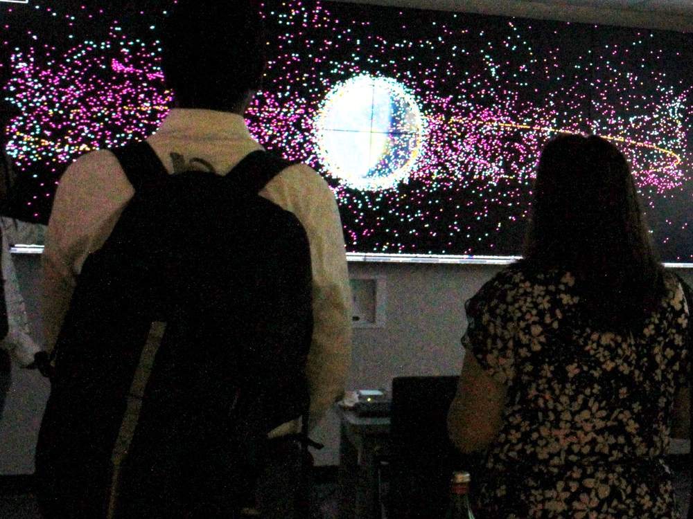 Students looking at monitor with space imagery
