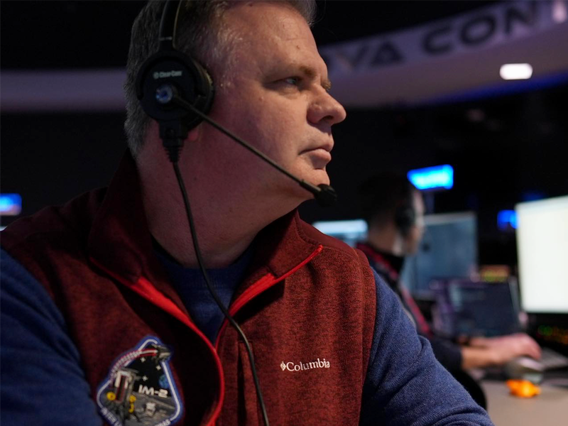 Alumnus Trent Martin wearing headset in control room.
