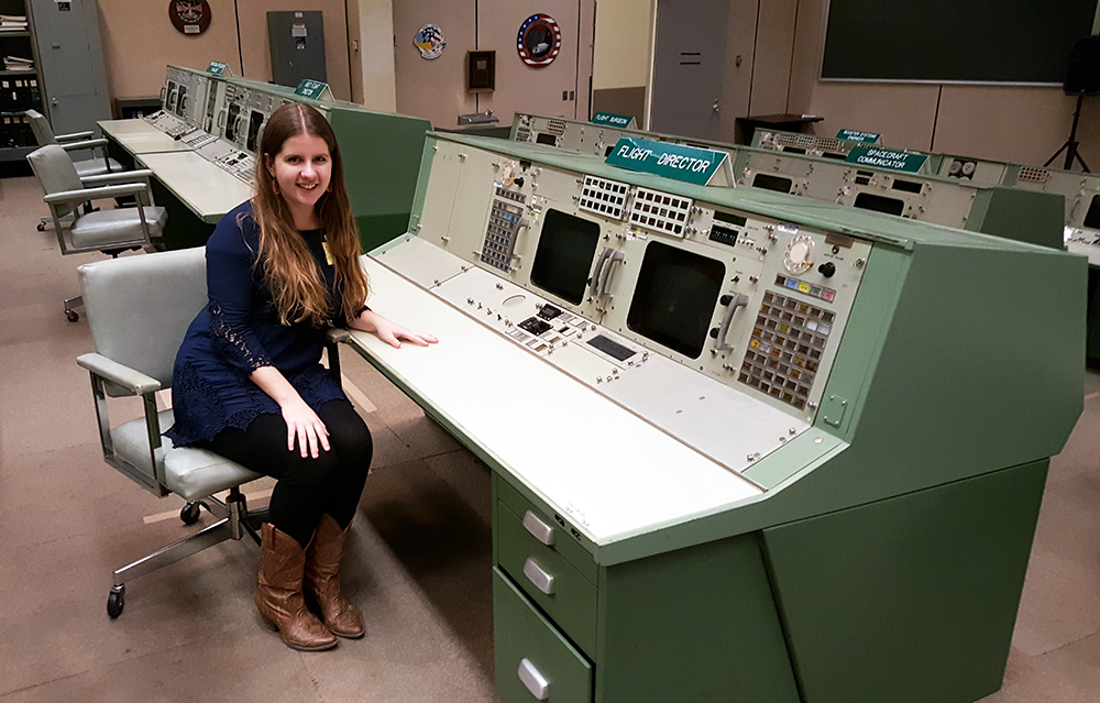 Ashliegh Caison smiling while sitting at mission control station.