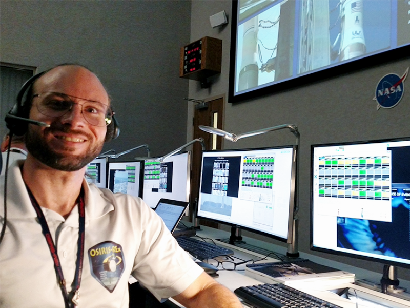 Alumnus Brent Barbee smiling in NASA control room.