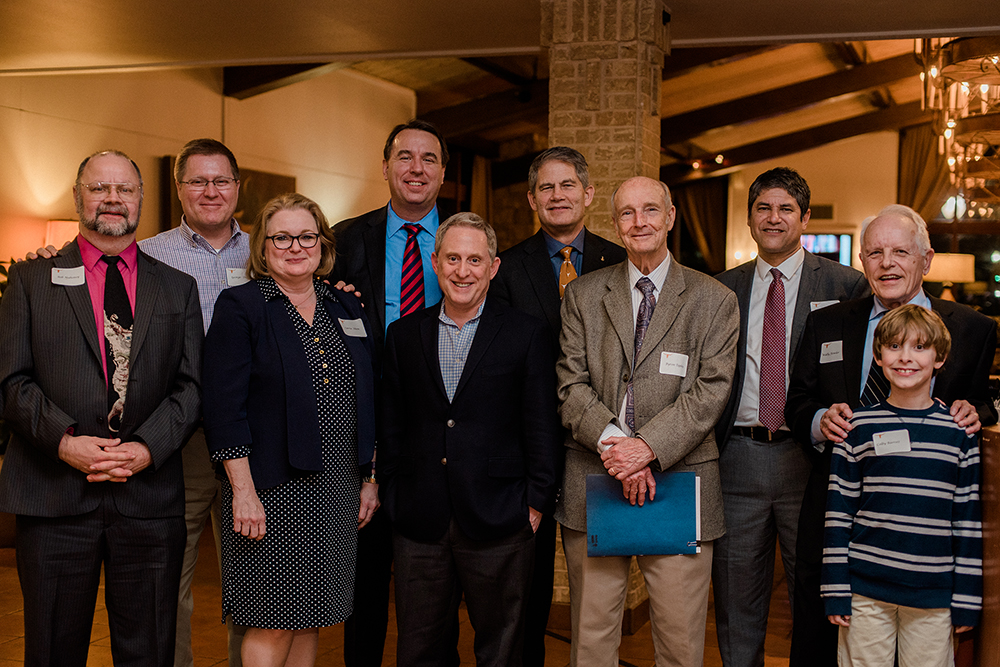 Wallace Fowler smiling with symposium and dinner speakers.
