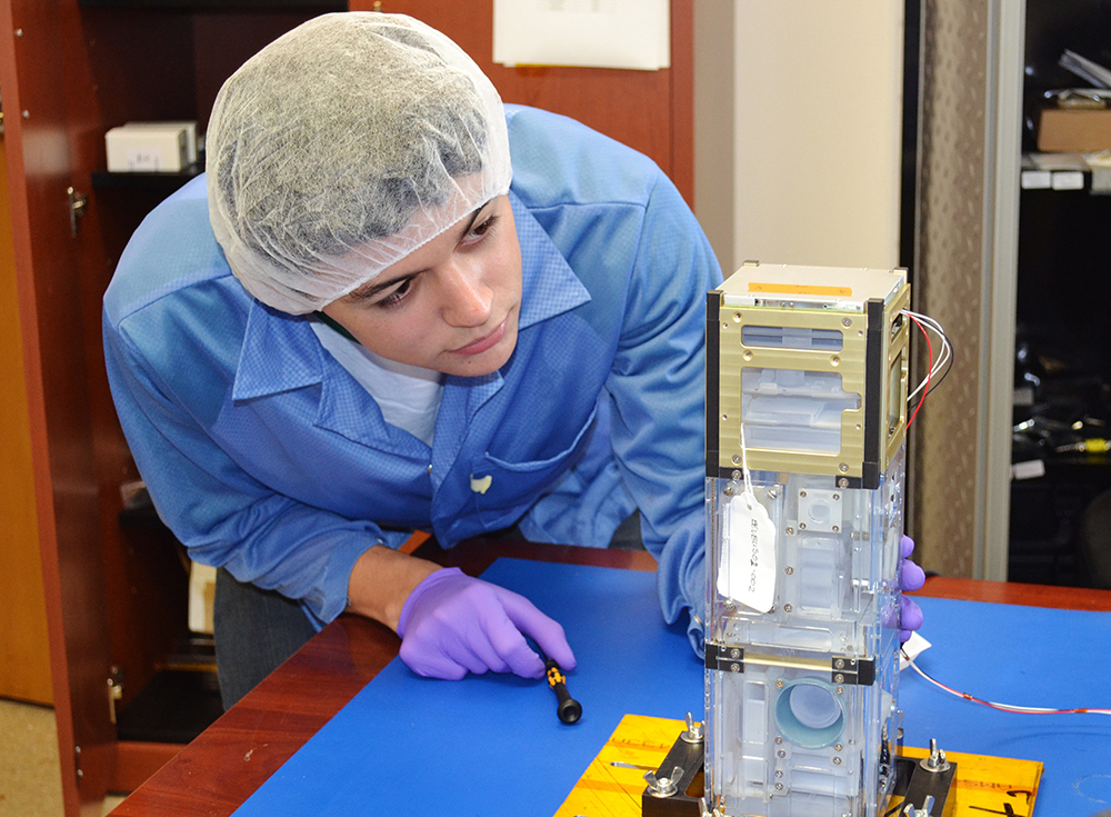 Student researcher Juan Ruiz inspects BEVO-2 prototype in lab.