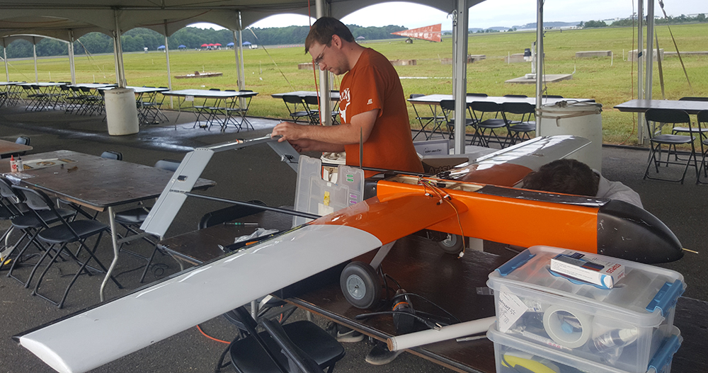 photo of student making adjustments to UAV
