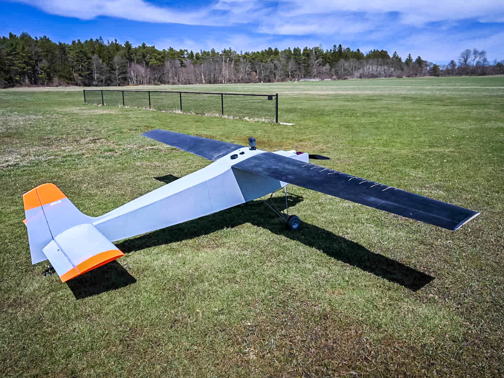 Self-aware unmanned aerial vehicle sitting in large open field.