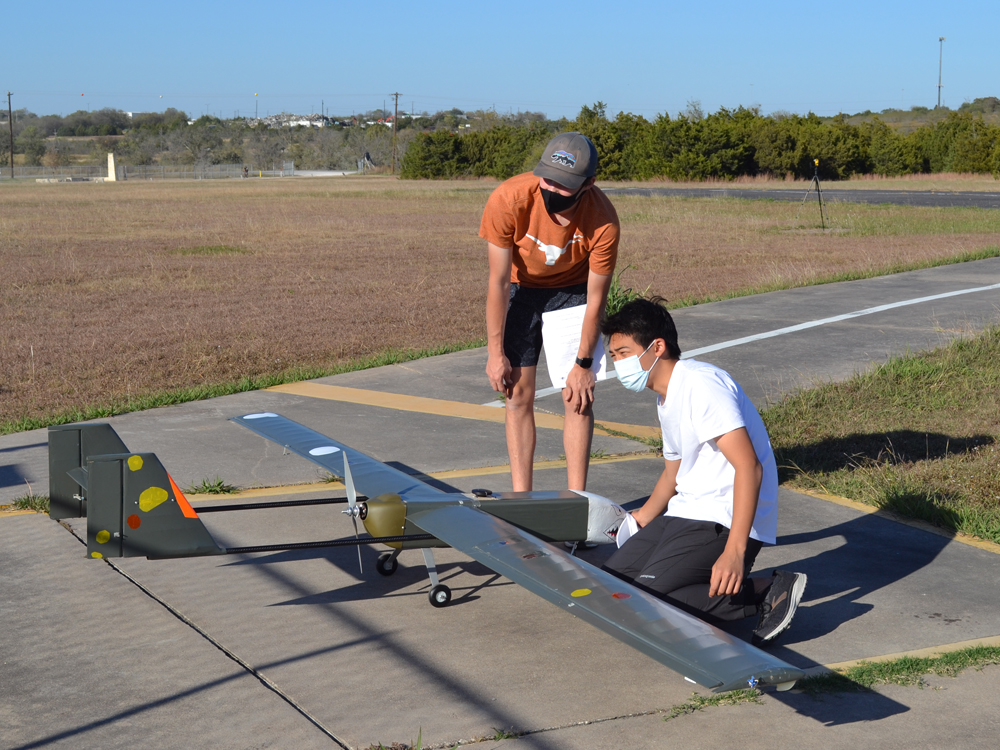photo of students with airplane on runway before flight