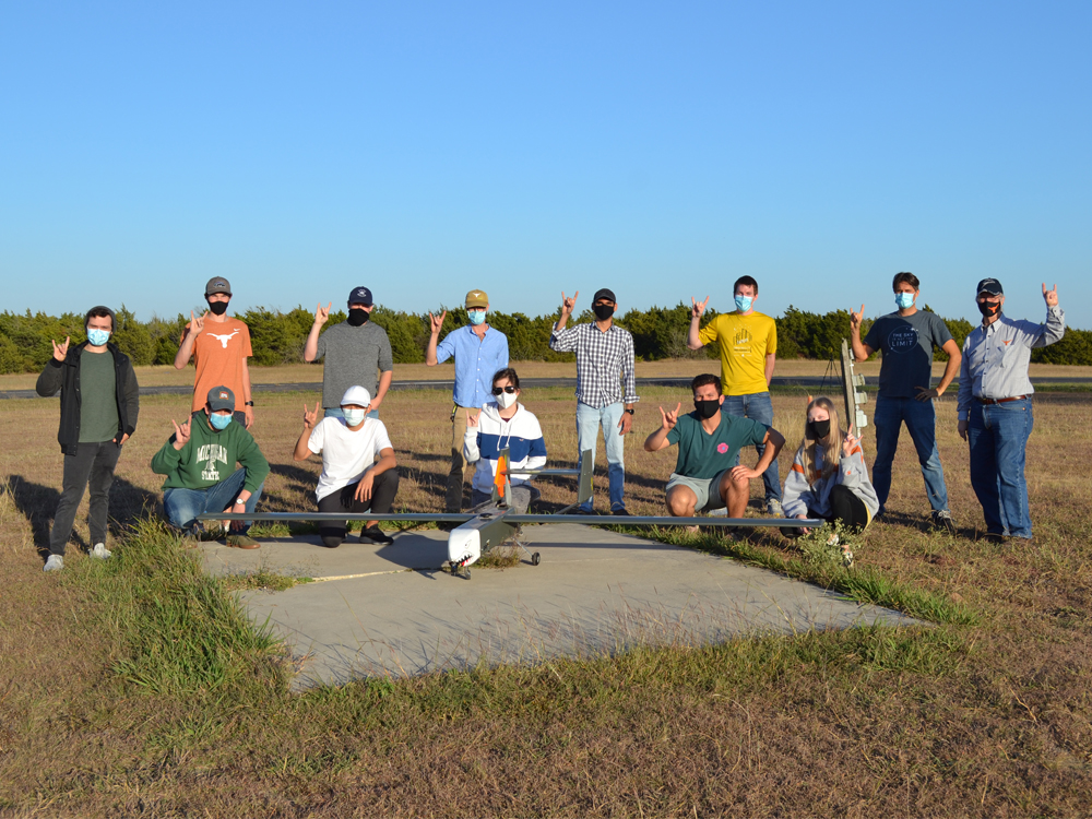 group photo of senior aircraft design team members with airplane