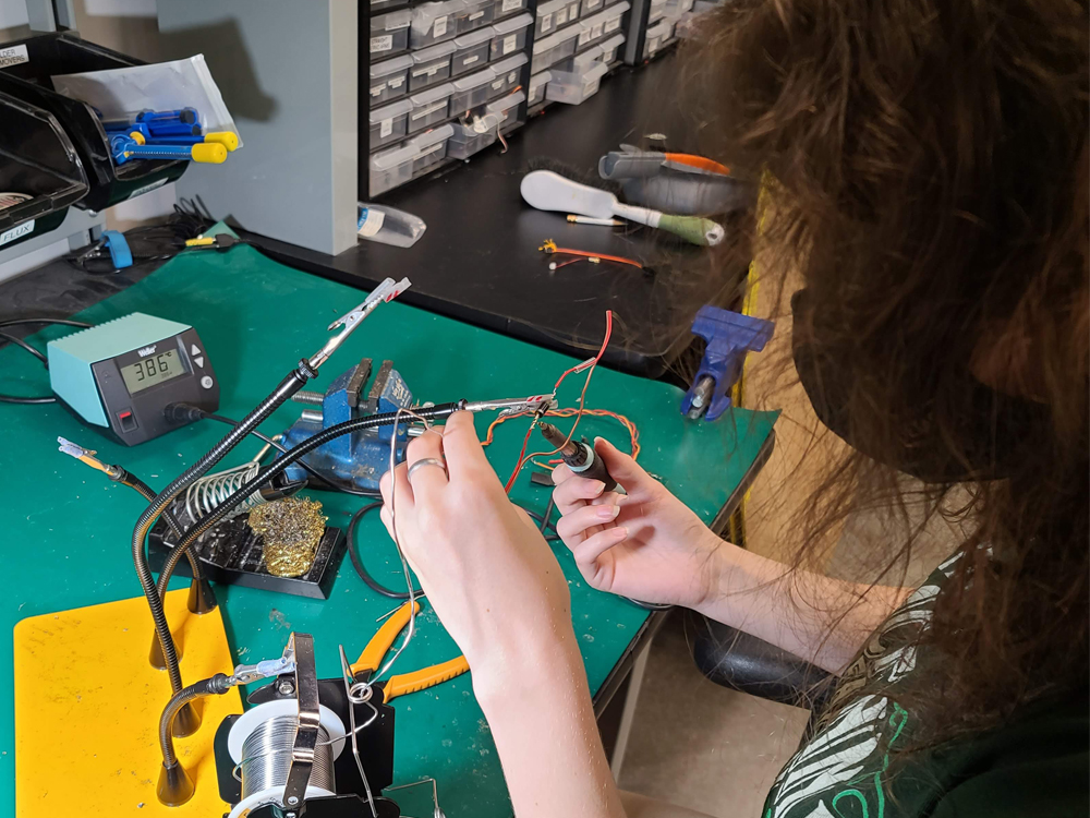 image of woman soldering aircraft parts in lab