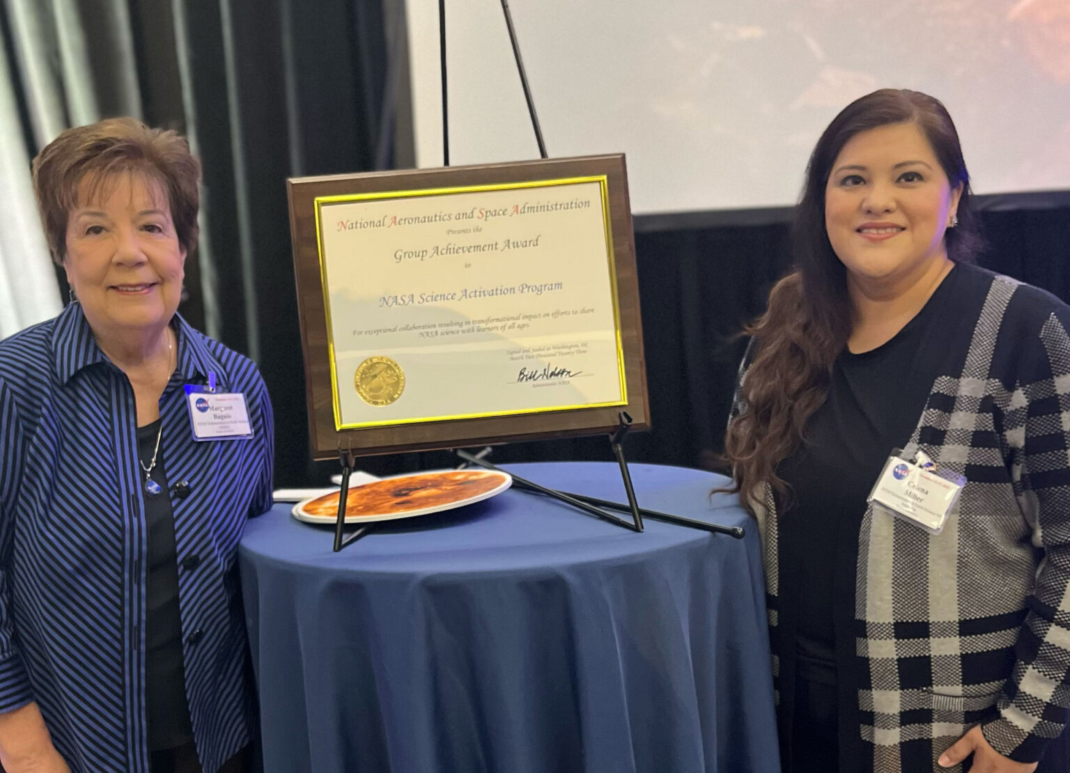 Photo of Margaret Baguio (left) and Celena Miller (right) of UT Austin's Center for Space Research with NASA Group Achievement Award that for the STEM Enhancement in Earth Science (SEES) High School Summer Internship Program.