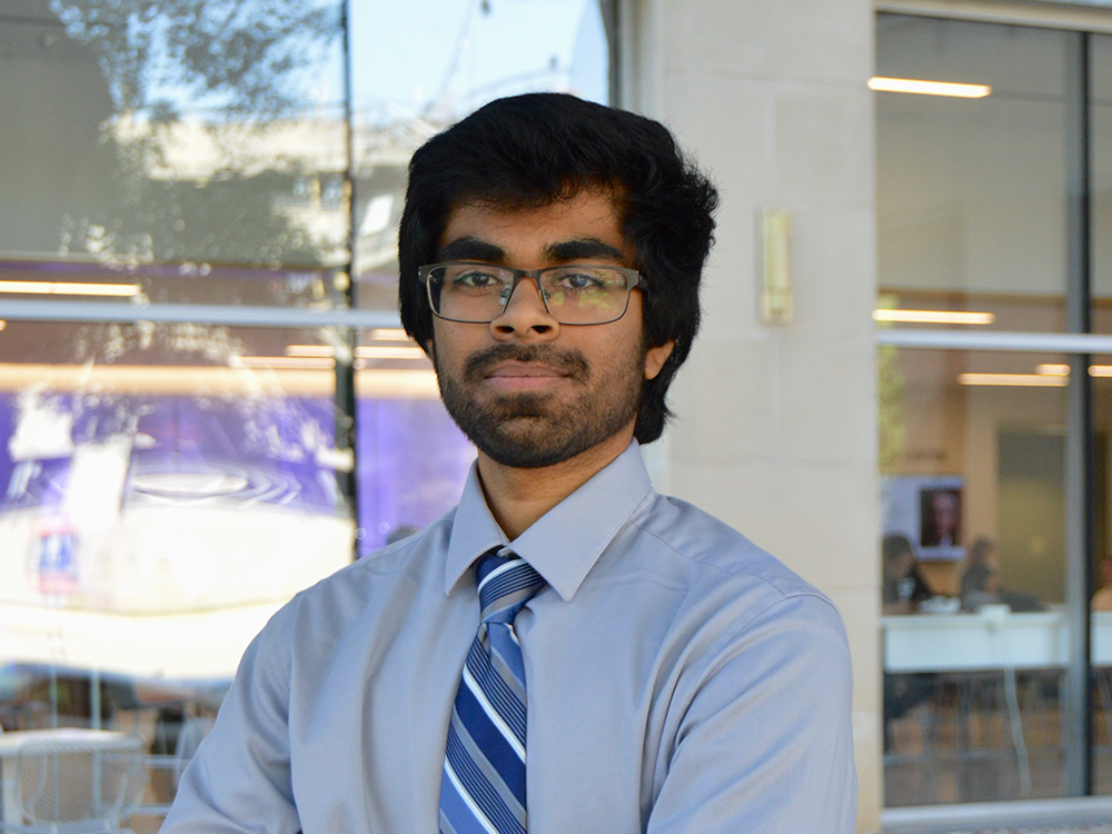 ASE/EM student Akhilesh Mulgund standing in front of glass doors with his arms crossed.