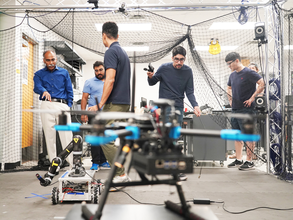 a drone in front of students working in robotics lab