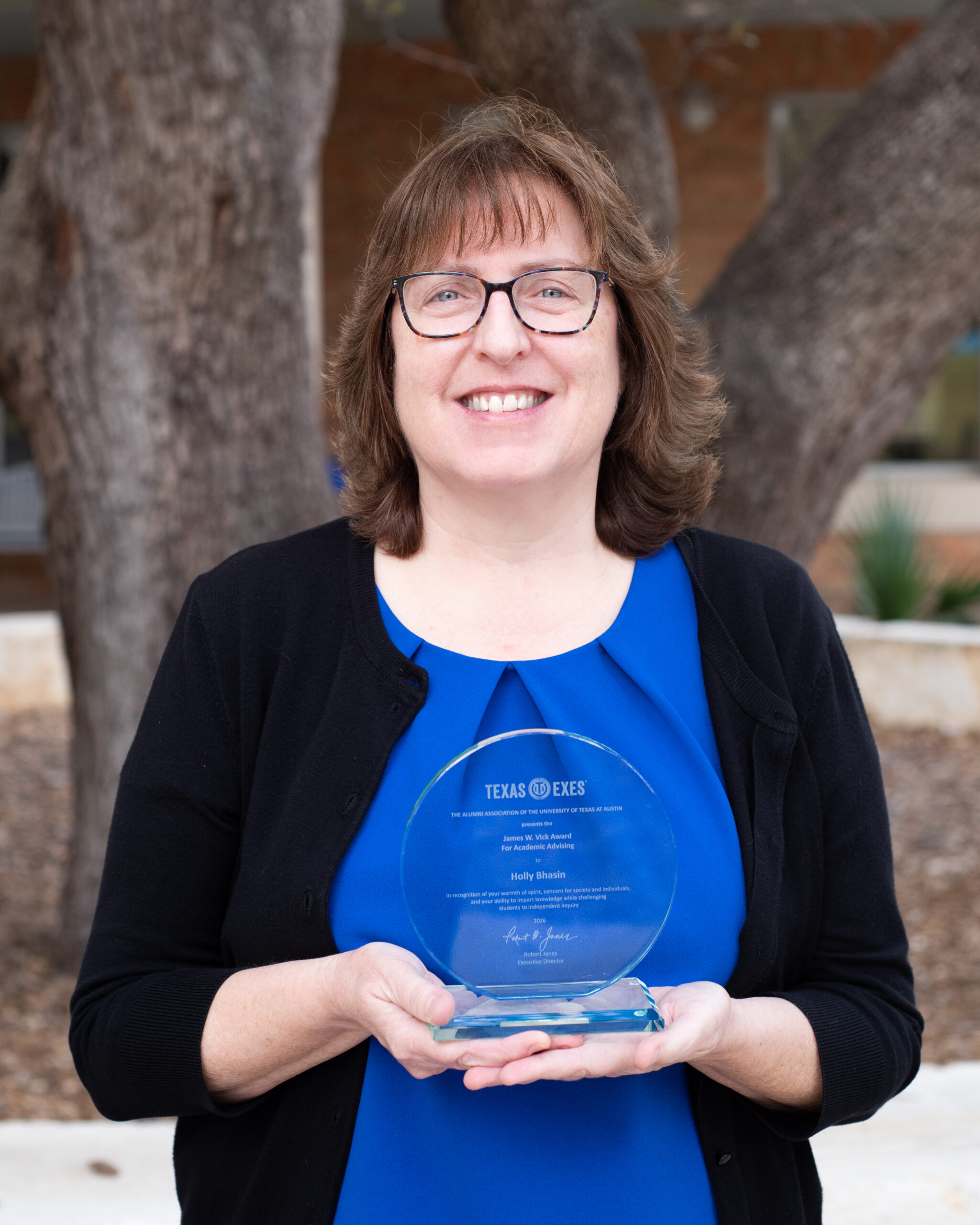 Holly Bhasin holding award