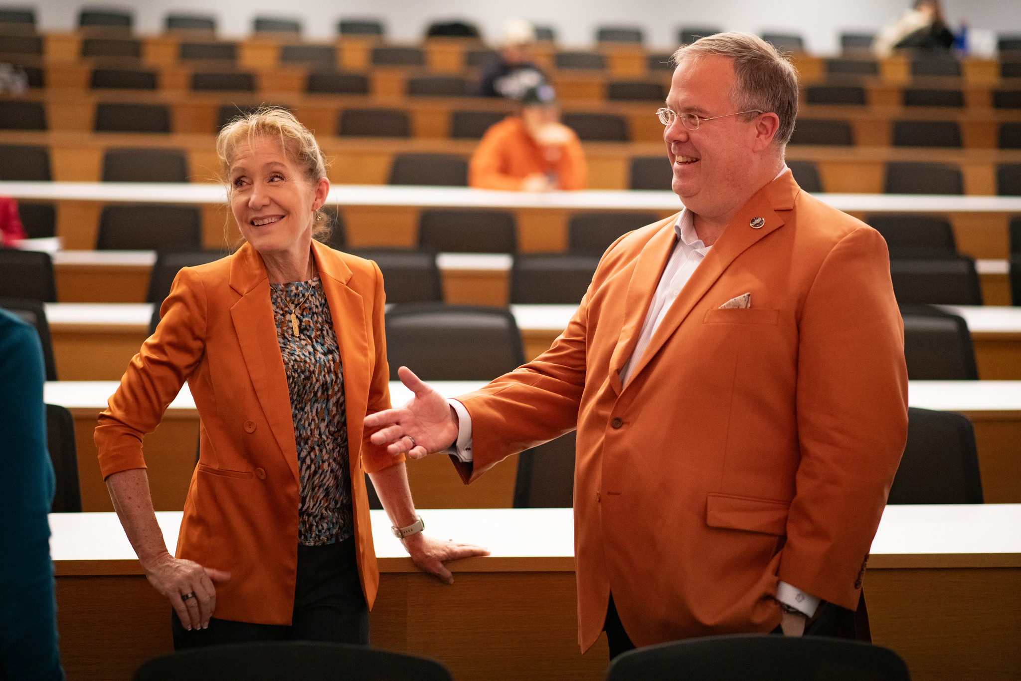 Alumni Tim Crain and Jeannie Leavitt talking in an auditorium.