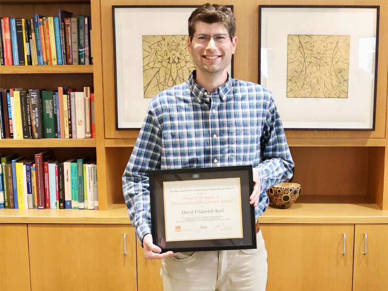 David Fridovich-Keil holding O'Donnell Award and smiling in front of bookcase.