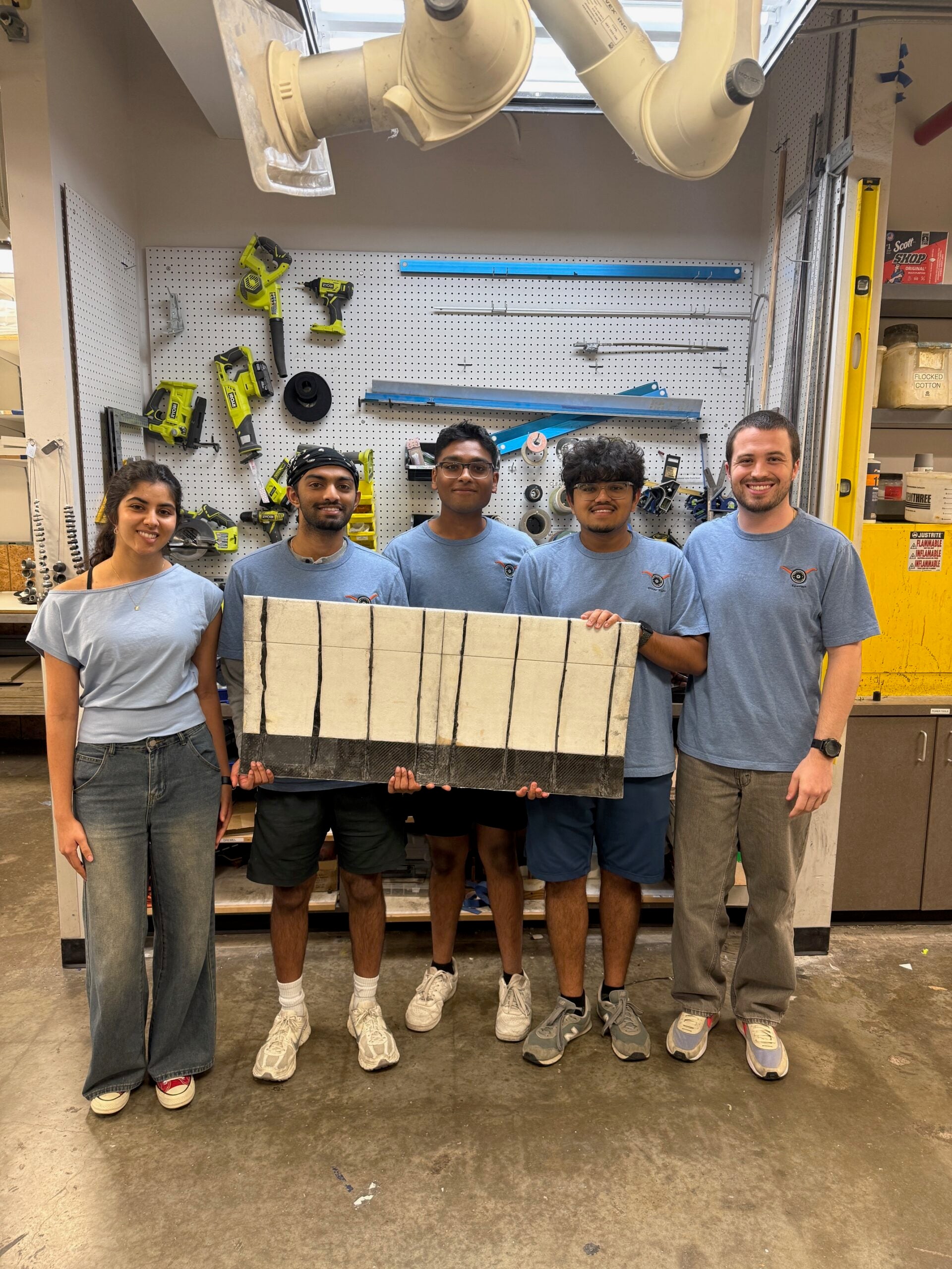 Five students pose with a piece of Sky Tug