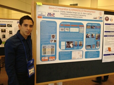 Jesus Charles poses with his research poster