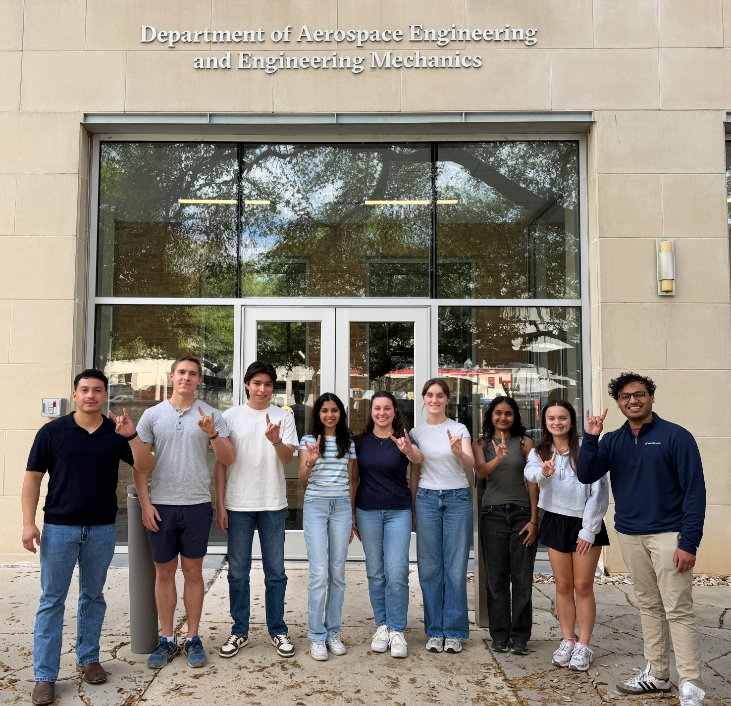 Project Pharos team smiling with a hook em hand sign