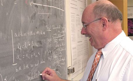 Leszek Demkowicz writing on chalkboard.