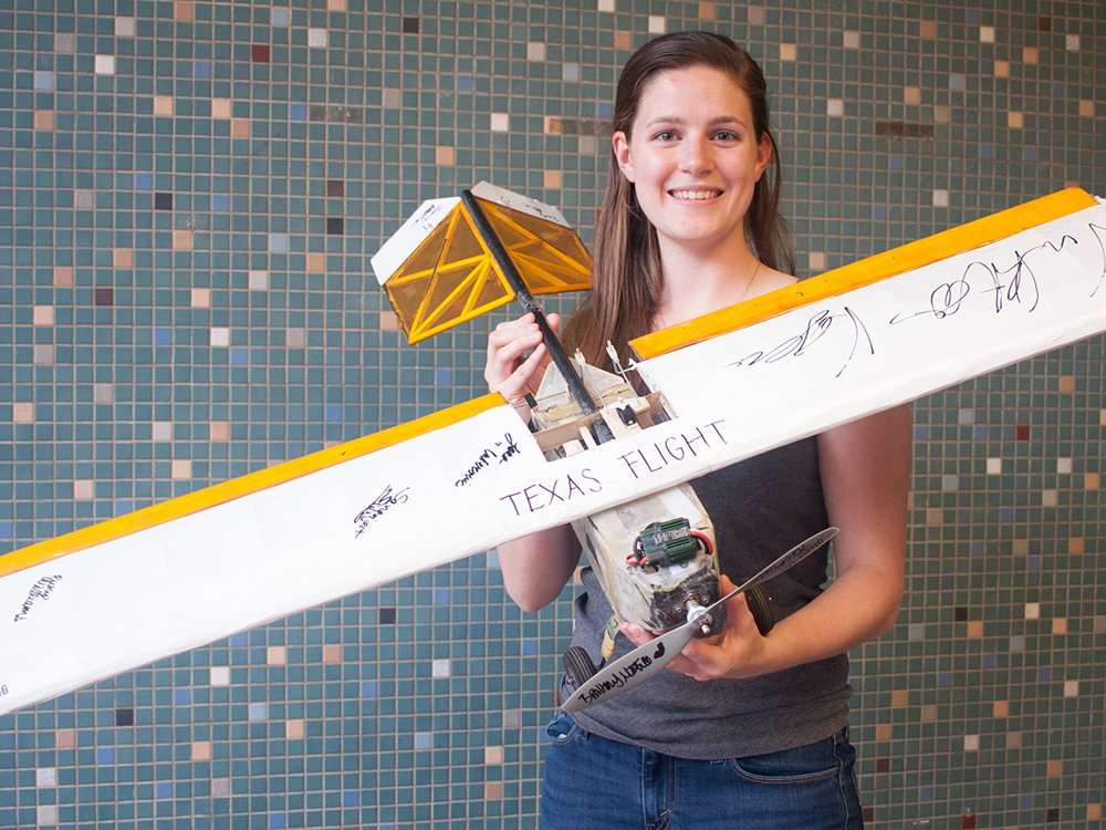 Caroline Bick holding airplane model with signatures